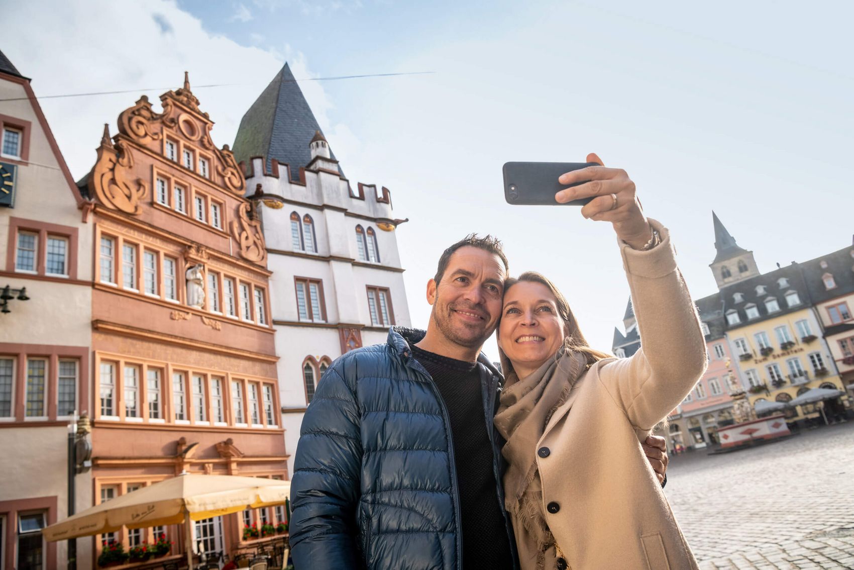 Trier, Hauptmarkt © Mosellandtouristik GmbH/Dominik Ketz Ansicht auf ein Paar, welches beim Flanieren über den Hauptmarkt in Trier gerade ein Selfie macht.