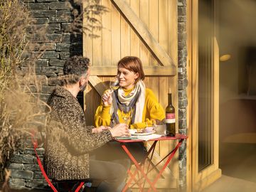 Zwei Personen an Tisch im Freien mit Wein und Tapas