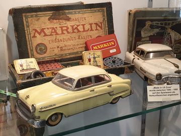 Glasvitrine mit historischen Spielzeugfahrzeugen