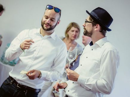 Weingenuss beim SaarRieslingSommer © schug design Zwei Männer unterhalten sich bei einem Glas Wein
