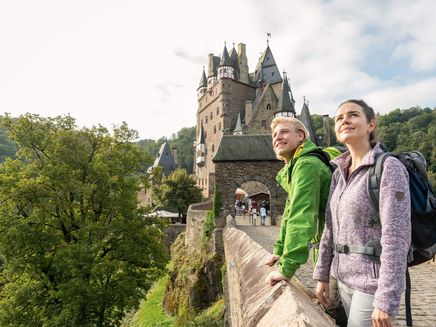 Burg Eltz, Highlight einer Mosel-Wanderung © Mosellandtouristik GmbH / Dominik Ketz Wanderer vor Burgenkulisse blicken in Ferne