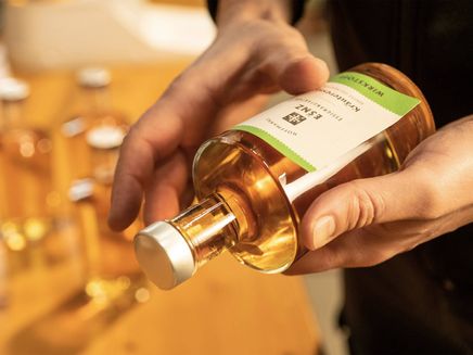 Winningen, Kräuteressig aus Eigenproduktion © Essigmannufaktur Hoffmann / Dominik Ketz Essigflasche mit weißem Etikett in Händen liegend