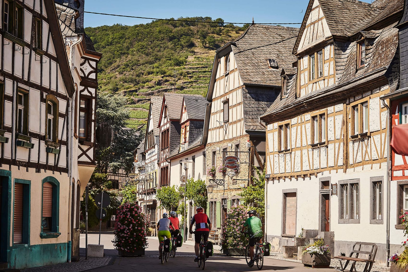 Untermosel, Winzerdorf mit Fachwerkhäusern © Marco Rothbrust Straßenansicht einer Fachwerkkulisse mit Radfahrern